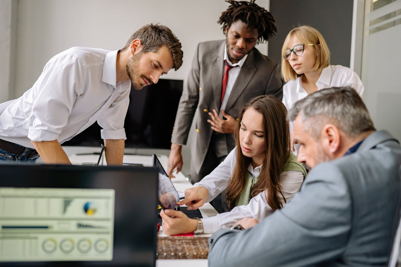 About A diverse team engages in a collaborative meeting in a modern office setting, focused on digital analysis.